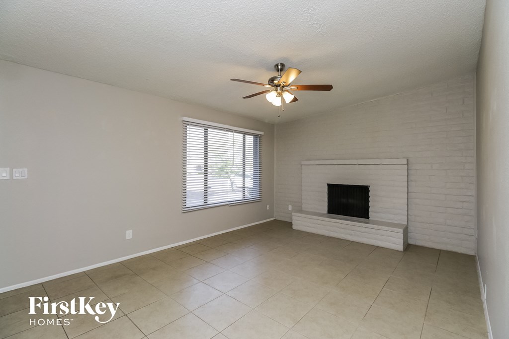 a living room with a fireplace and a ceiling fan