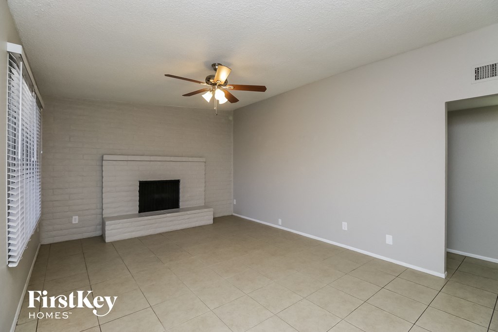 a living room with a fireplace and a ceiling fan