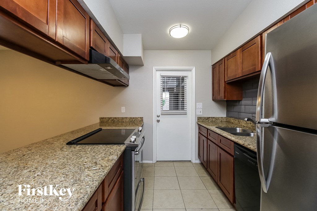 a kitchen with granite countertops and stainless steel appliances and wooden cabinets