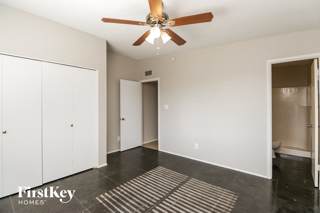 a living room with white walls and a ceiling fan