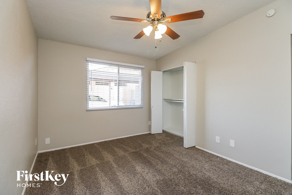 the spacious living room with carpeting and a ceiling fan