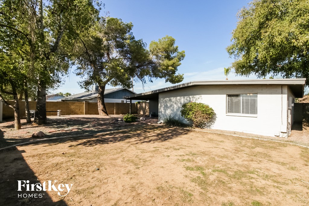 a small white house with a yard and trees