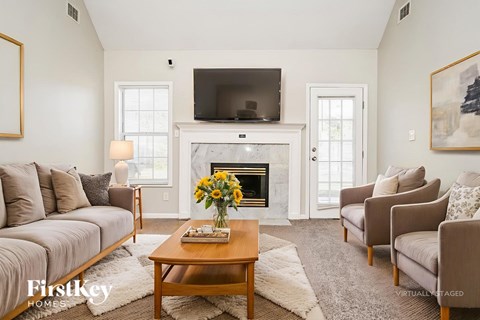 A living room with a fireplace and a television mounted above it.