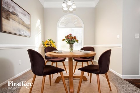 A dining room with a wooden table and chairs.