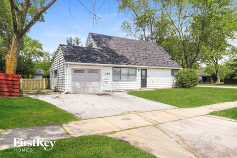 a small white house with a garage and a driveway