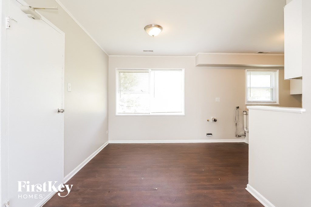 an empty living room with white walls and a window