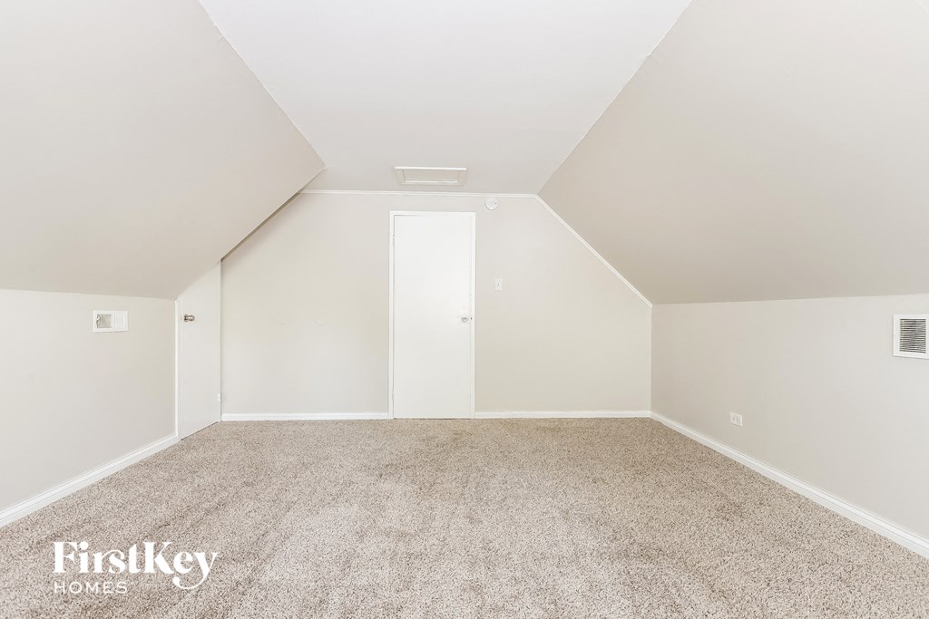 a empty bedroom with a carpeted floor and white walls