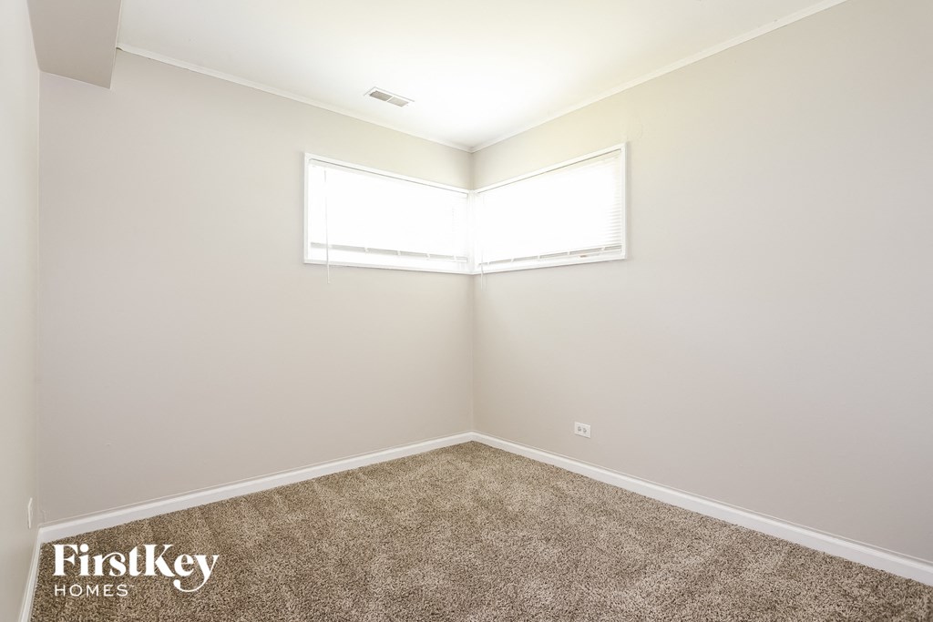 a empty room with carpet and a window