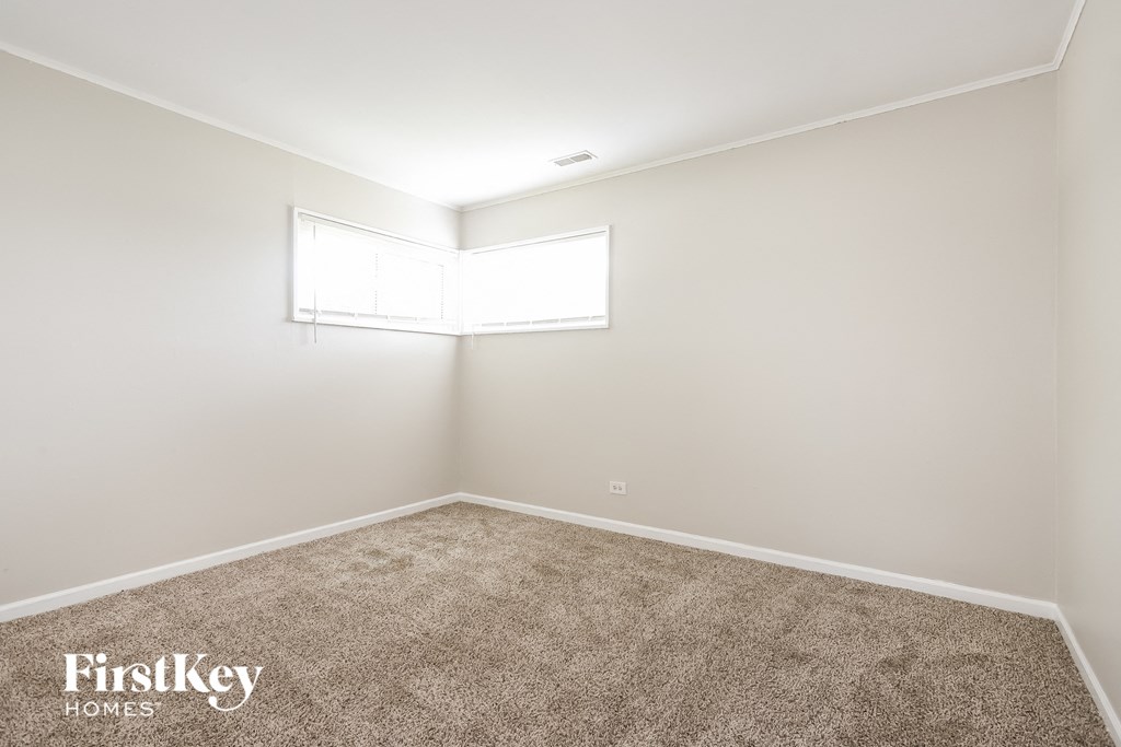 a empty room with carpet and a window
