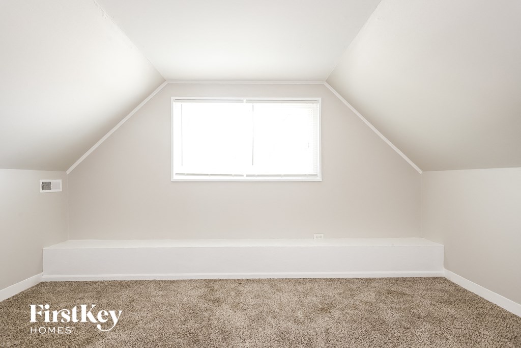 the upstairs bedroom with carpet and a window