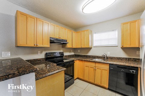 a kitchen with wood cabinets and granite counter tops and black appliances