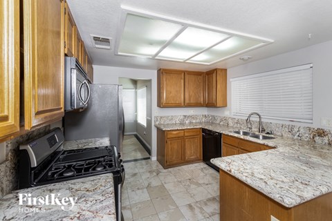 A kitchen with granite countertops and wooden cabinets.