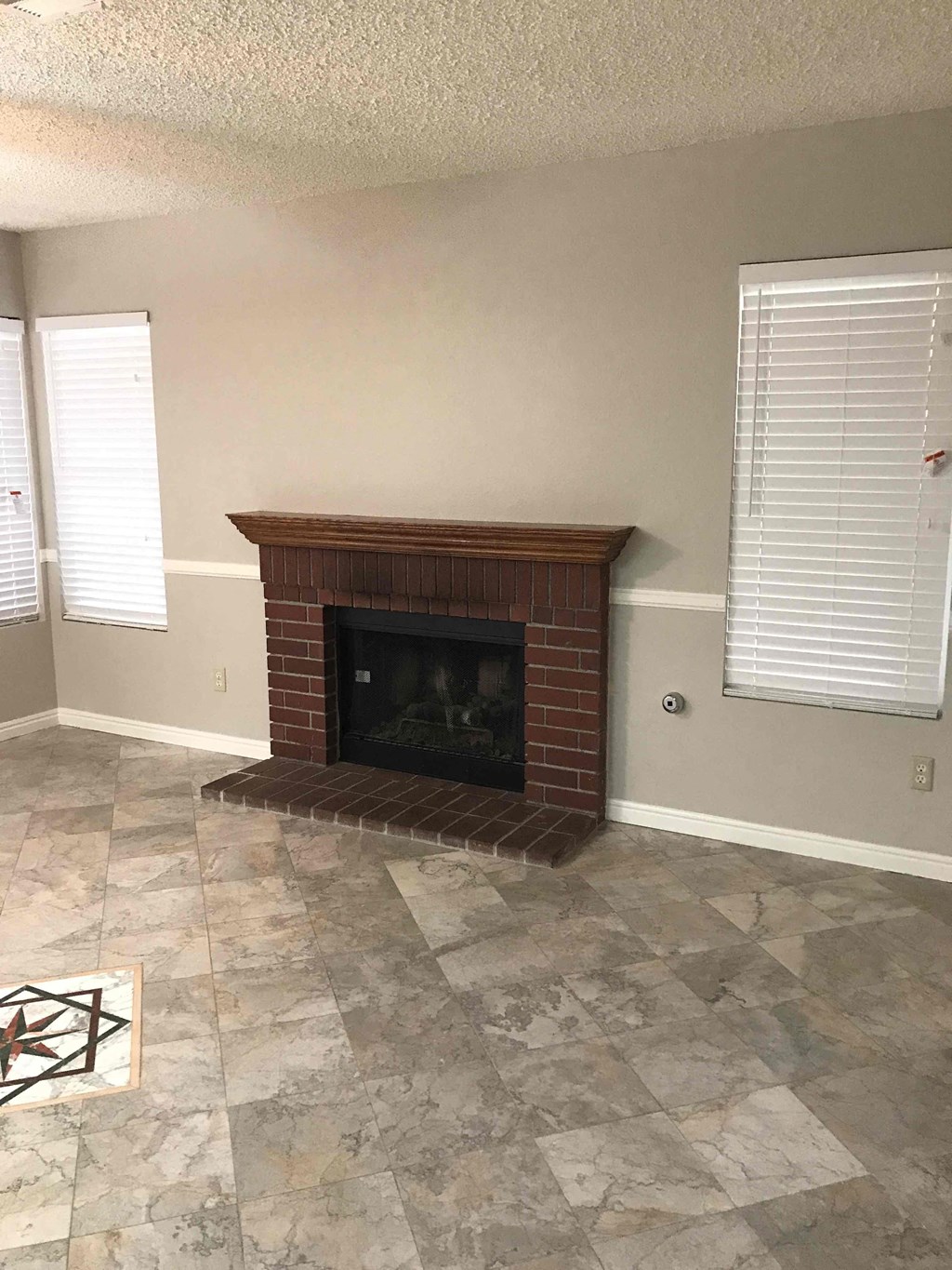 a living room with a fireplace and a tiled floor