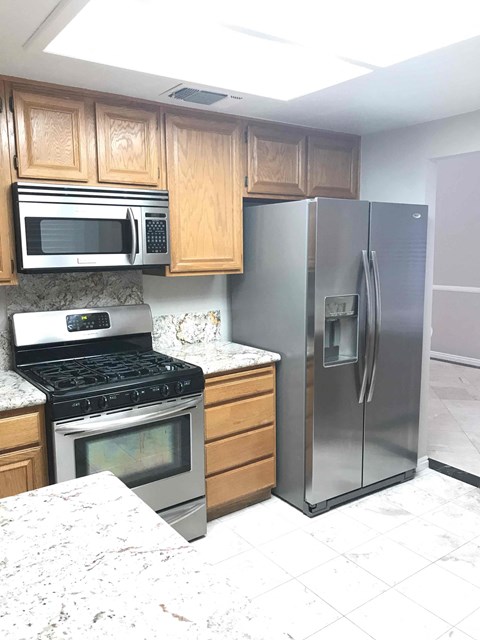 a kitchen with a stove refrigerator and microwave