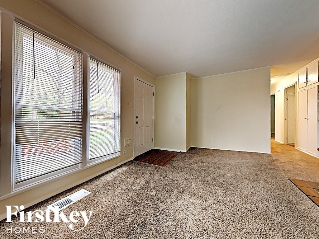 the living room of an empty house with a large window