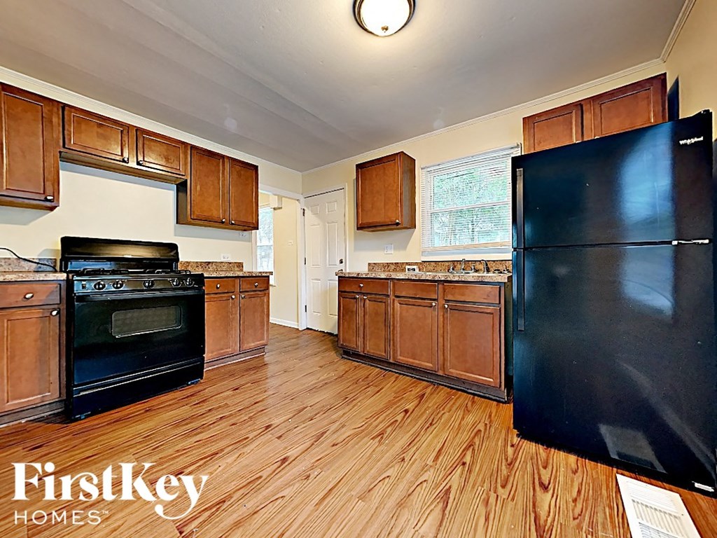 a kitchen with black appliances and wooden floors
