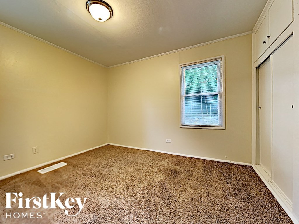 an empty room with a window and a closet