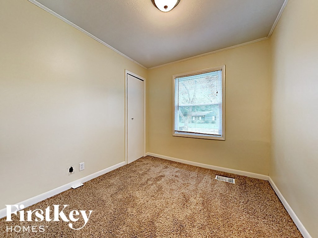 the living room of an empty house with a window and carpet