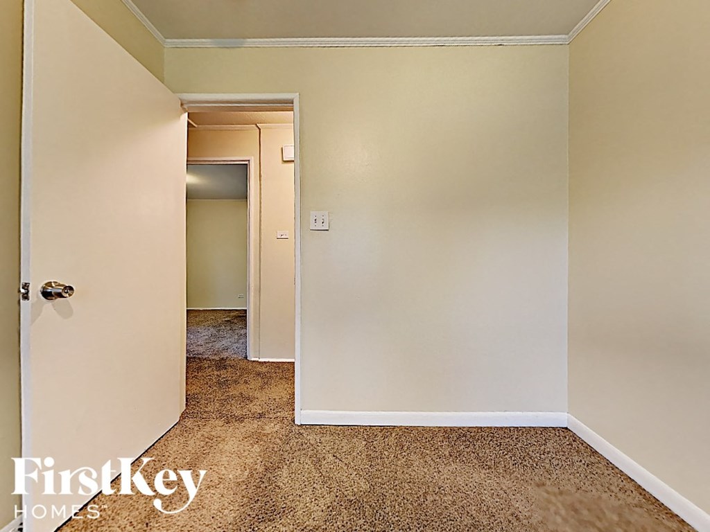 a small hallway with an open door to a bedroom