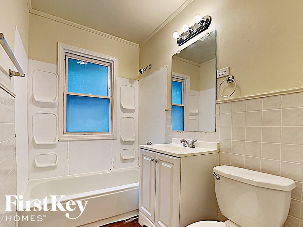 a white bathroom with a toilet sink and bath tub