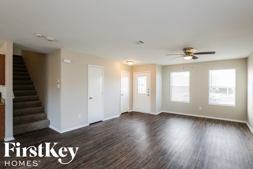 a living room with wood floors and a ceiling fan
