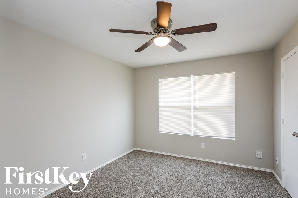 a bedroom with a ceiling fan and a window