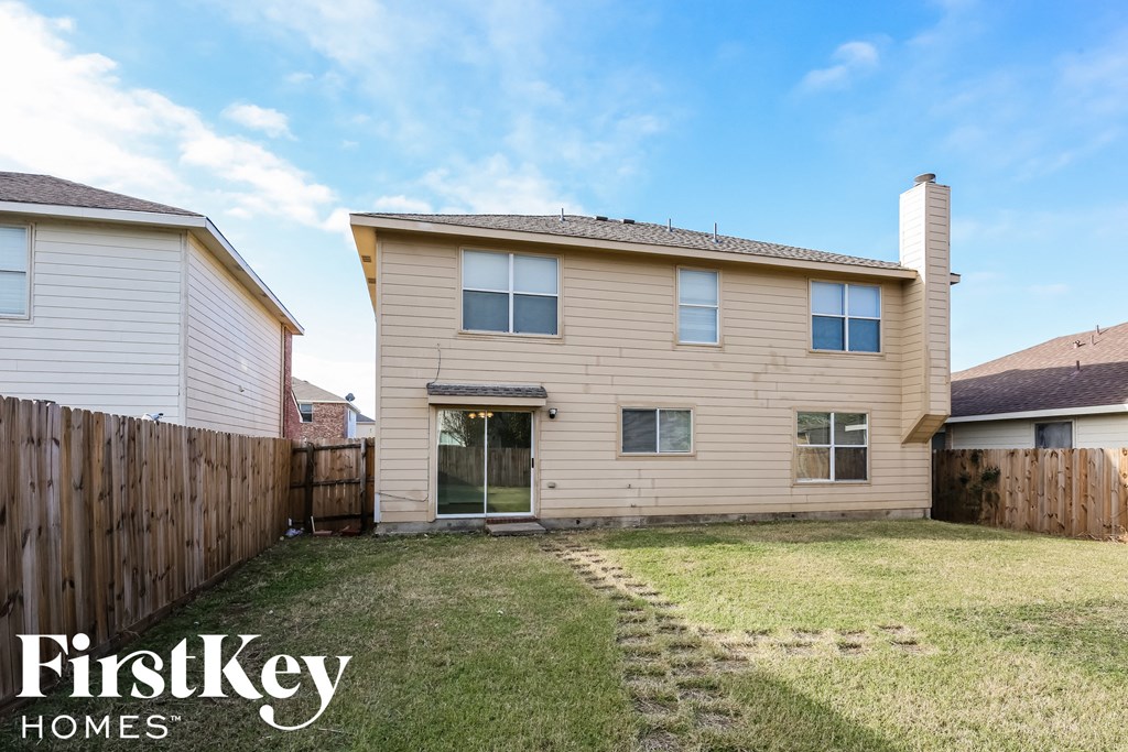 the backyard of a house with a yard and a fence
