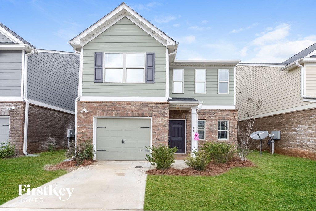 A house with a garage and a driveway in front.