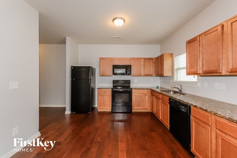 A kitchen with wooden cabinets and black appliances.
