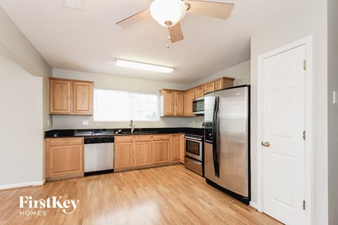A kitchen with wooden cabinets and a black countertop.