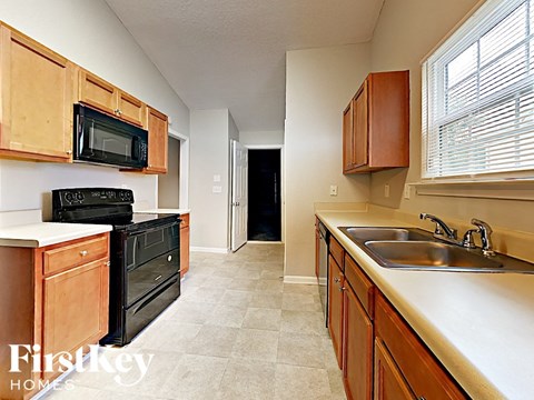 a kitchen with wood cabinets and black appliances and a sink