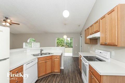 A kitchen with wooden cabinets and white appliances.