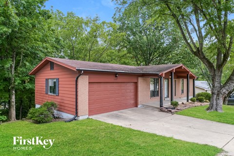 a small red house with a sidewalk in front of it