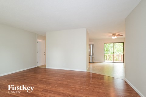 an empty living room with white walls and wood floors
