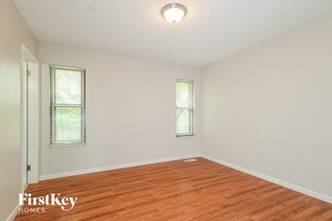 a living room with a hardwood floor and white walls