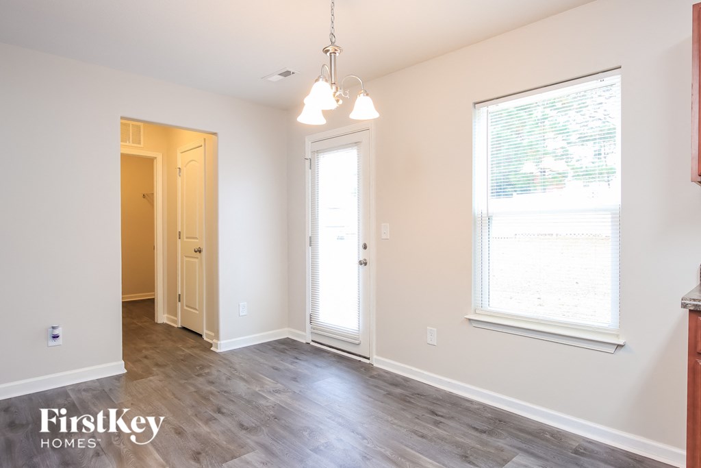 a living room with white walls and a wood floor