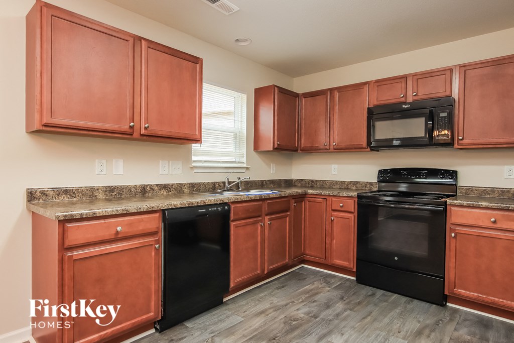 a kitchen with wooden cabinets and black appliances