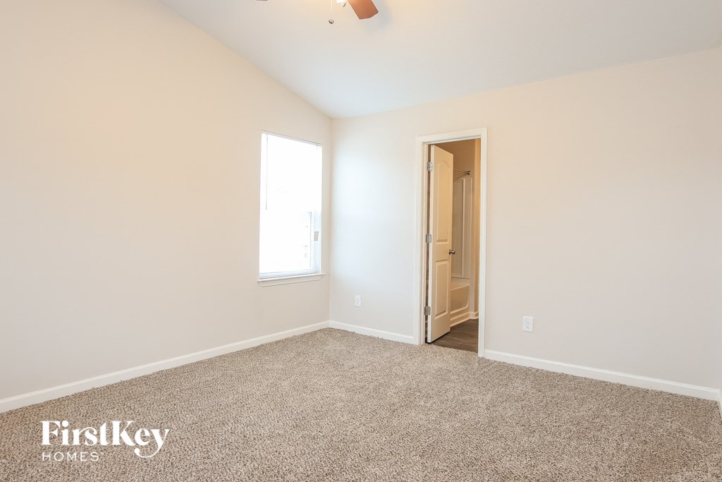 a bedroom with carpet and a door to a bathroom