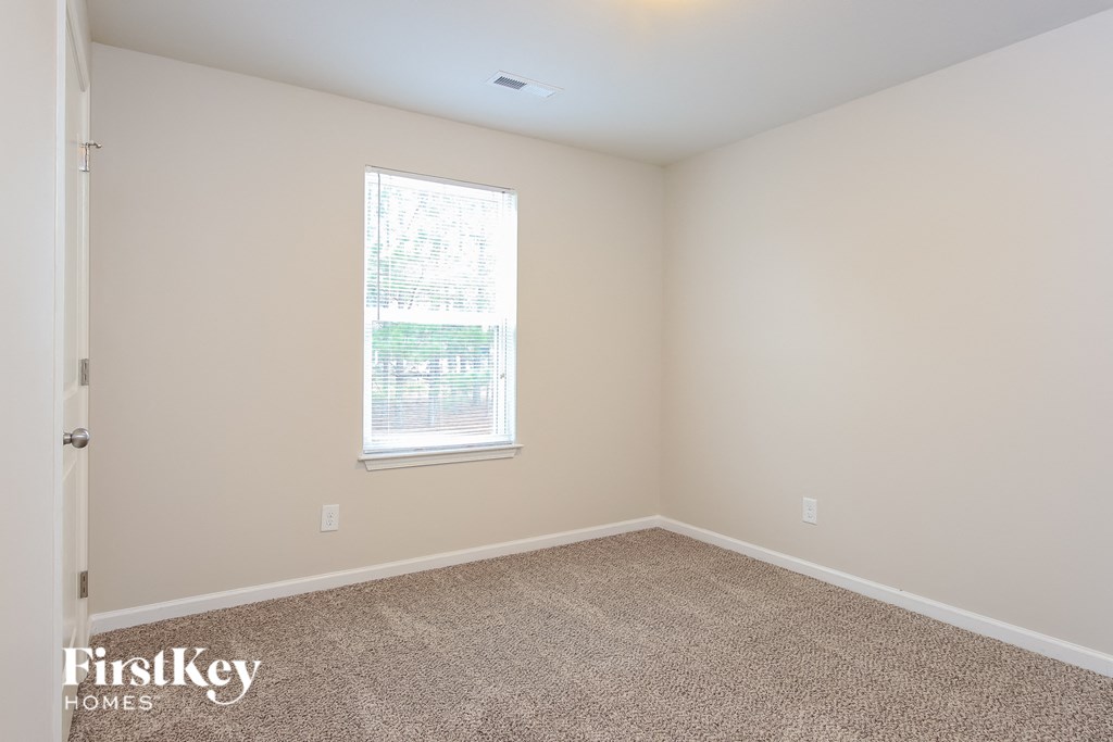 a empty room with carpet and a window