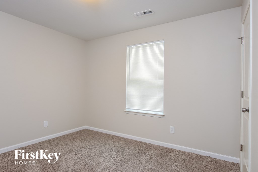 a bedroom with a carpeted floor and a window