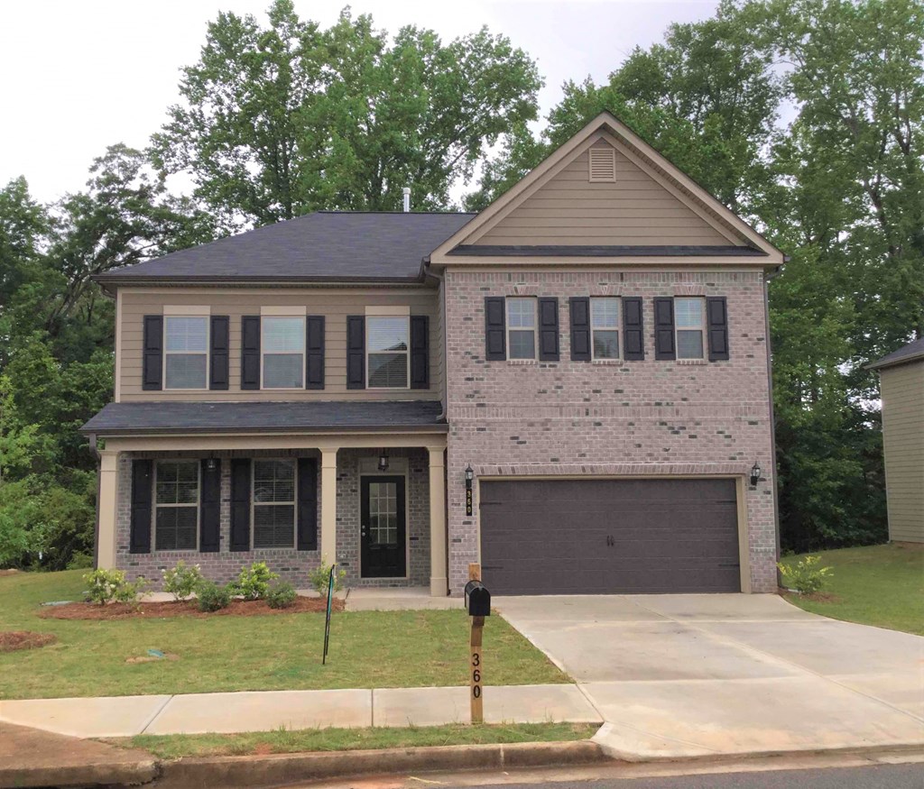 A two-story house with a garage and a driveway.