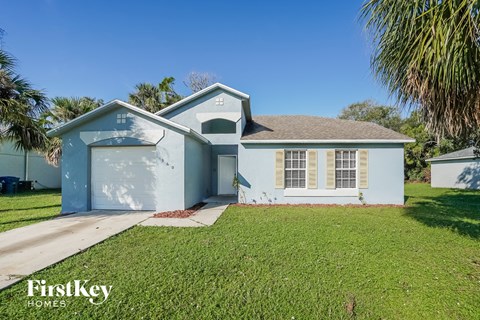 a light blue house with a lawn and a garage