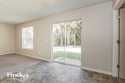 an empty living room with a sliding glass door to the yard
