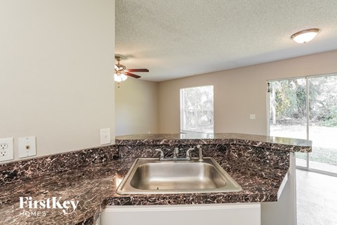 the kitchen has granite counter tops and a stainless steel sink