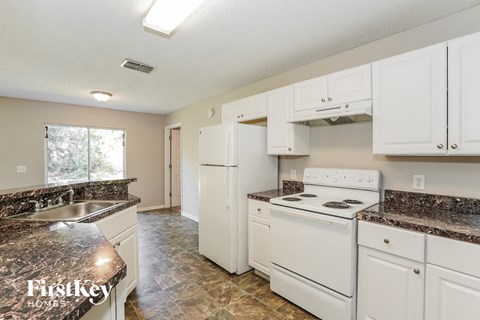 a kitchen with white appliances and granite counter tops