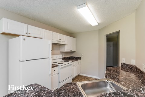 a kitchen with white appliances and granite counter tops and a white refrigerator