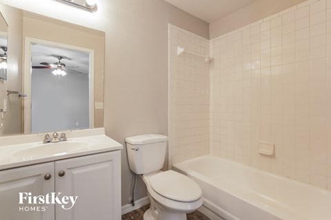 a white bathroom with a toilet and a tub and a sink