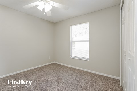 a bedroom with a ceiling fan and a window