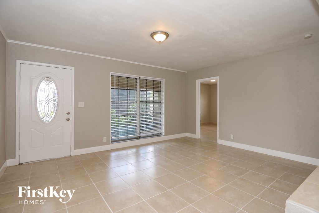 A spacious room with a door and a window with blinds.