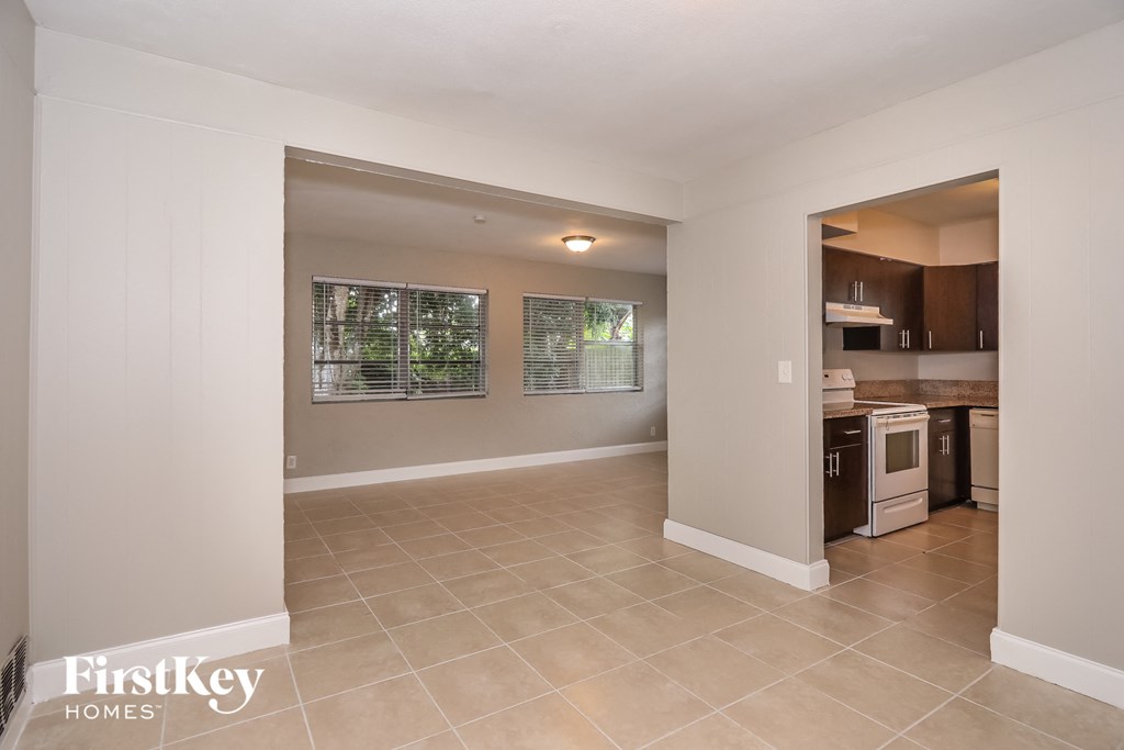 A spacious room with a kitchen area visible through the doorway.